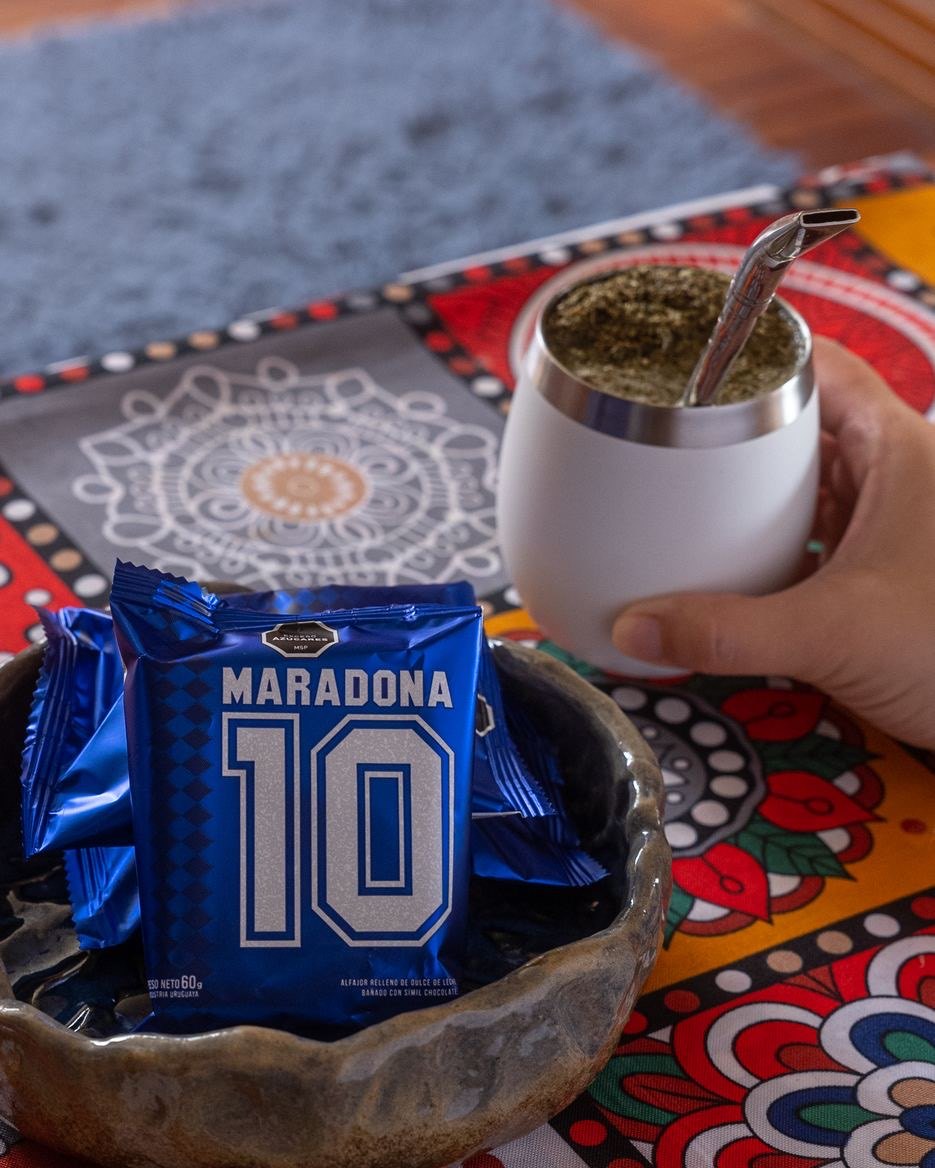 Un Alfajor Maradona apoyado junto a un mate, sobre un mantel